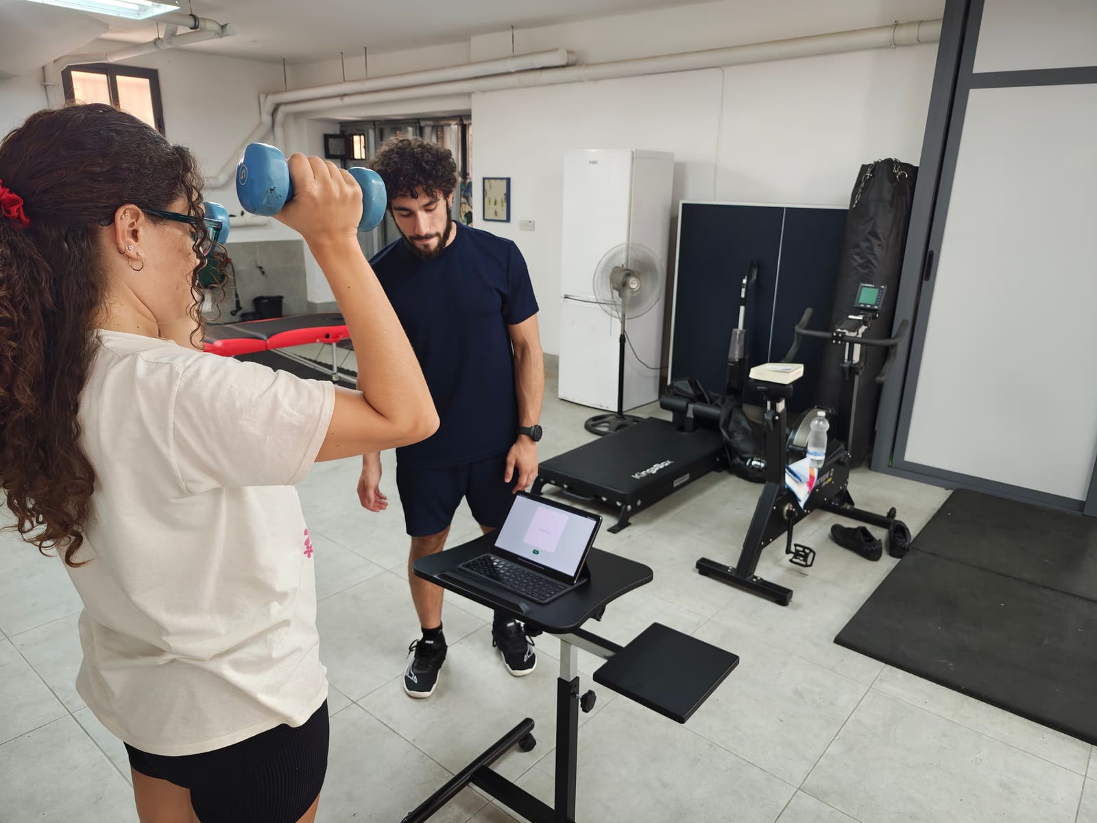 Coaching a dumbbell curl with the tool running nearby